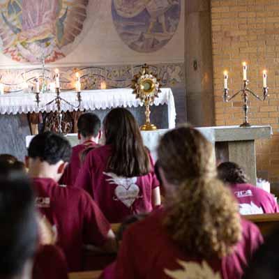 Students kneel during Eucharistic Adoration