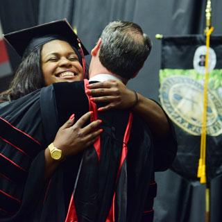 President Minnis hugging a graduate.